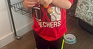 Hayse is registered to the contest to win money with this photo: child, boy, toddler, blond_hair, standing, portrait, indoor, home, toy, beads, colorful, red_shirt, sportswear, black_pants, socks, pet_cage, cage, sofa, wooden_floor, playing