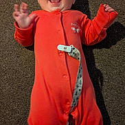 Eleanor joined the competition — help win amazing prizes! baby, carpet, child, clothing, cute, expression, face, hands_up, happy, indoors, infant, joyful, laughing, lying_down, orange_onesie, person, playful, skin, smiling, toddler