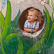 Mayzie participe au concours pour gagner de l'argent avec cette photo : art, child, colorful, curious, curly_hair, cute, expression, face, flowers, greenery, nature, outdoor, painting, playground, portrait, scrunchie, sleeves, toddler, tree_trunk, window