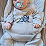 baby, sleeping, pacifier, dinosaur_print, onesie, baby_seat, infant, child, soft_fabric, cute, resting, cozy, small_hands, footed_pajamas, comfort, indoor, peaceful, childcare, young, naptime