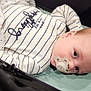 Cooper is registered to the contest to win money with this photo: baby, infant, pacifier, onesie, striped_clothing, blanket, star_pattern, face, head, blue_eyes, lying_down, soft_surface, indoors, child, newborn, cute, calm, person, sleepwear, closeup