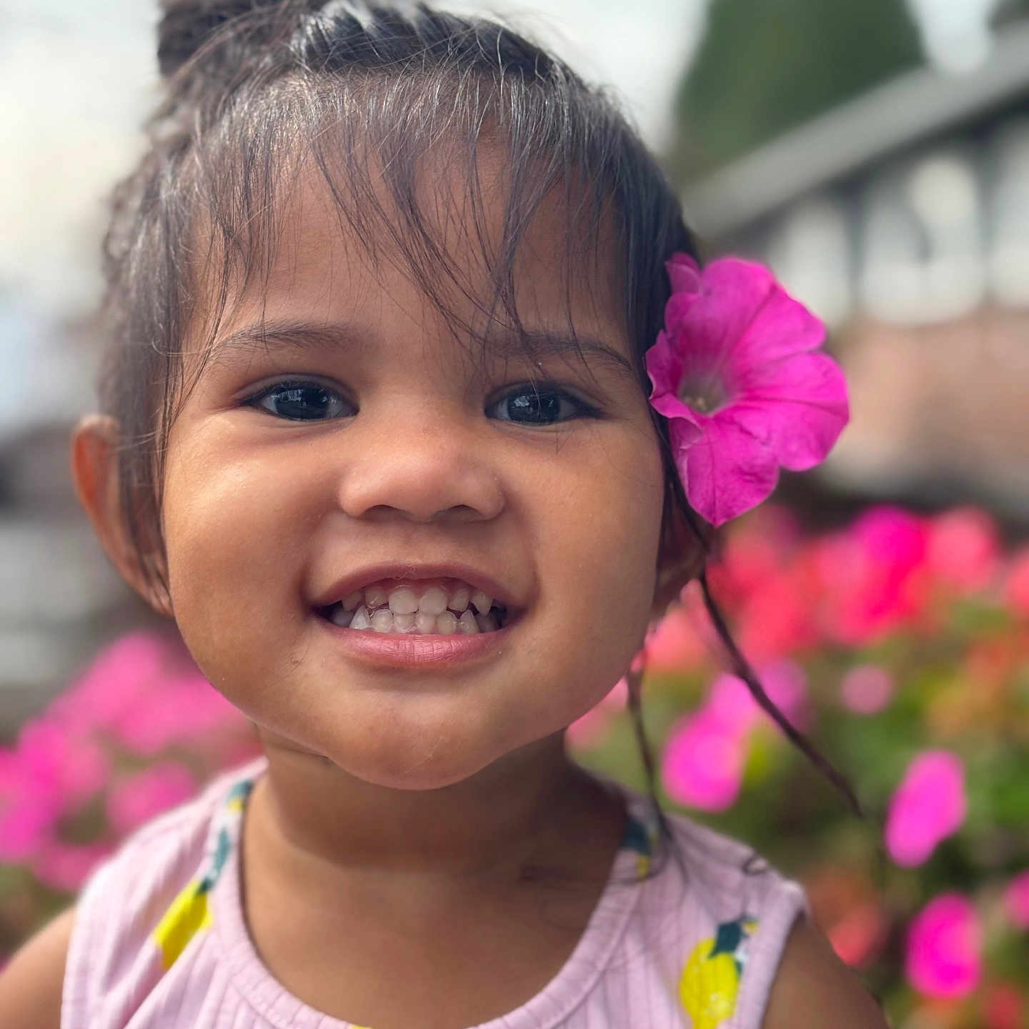 Esther is registered to the contest to win money with this photo: background_blur, blossom, child, closeup, colorful, cute, face, flower, garden, girl, hair, happy, nature, outdoor, pink_flower, portrait, smile, summer, tank_top, young_child