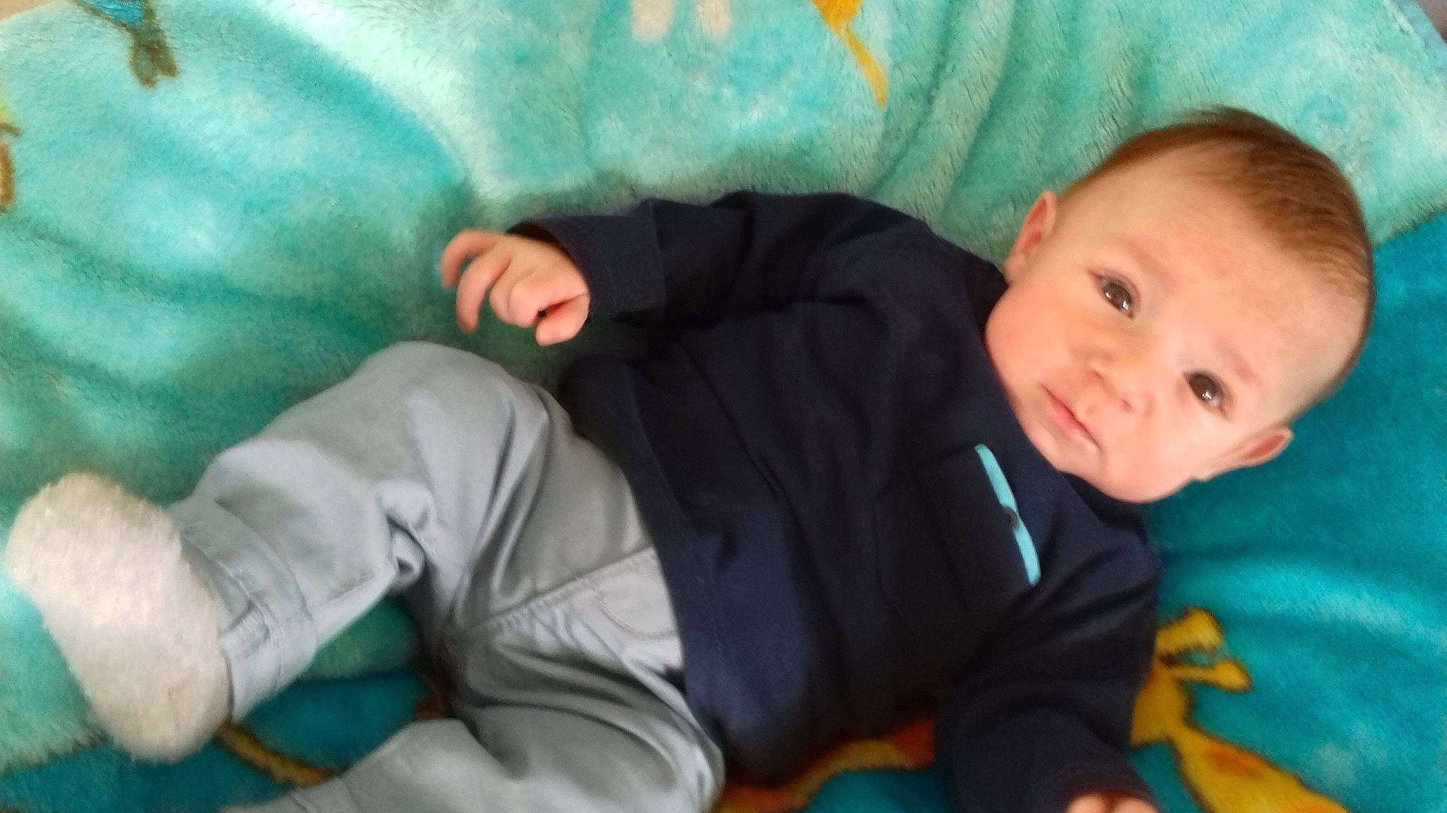 Isaak participe au concours pour gagner de l'argent avec cette photo : azure, baby, baby_products, baby_toddler_clothing, cheek, child, comfort, eye, finger, fun, head, linens, mouth, nose, person, room, sitting, skin, smile, textile