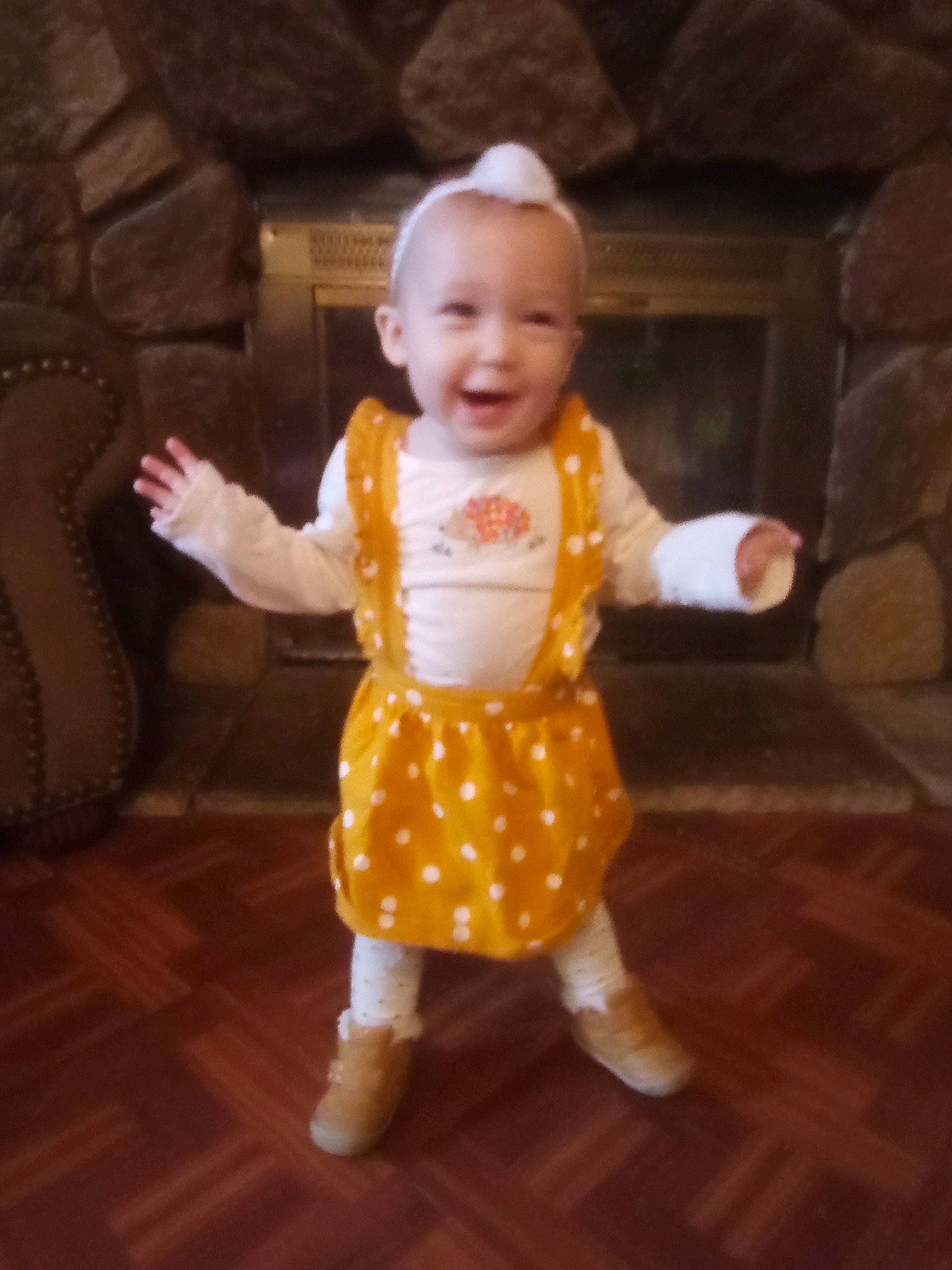 Mahayla is registered to the contest to win money with this photo: baby, baby_toddler_clothing, cheek, face, finger, floor, flooring, fun, gesture, happy, hardwood, head, human_body, joy, person, sitting, skin, sleeve, smile, thumb