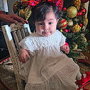 Gianna joined the competition — help win amazing prizes! toddler, child, white_dress, red_bow, red_shoes, chair, hand, christmas_tree, christmas_ornaments, holiday, decorations, indoors, wood_floor, festive, portrait, cute, smile, person, celebration, seasonal