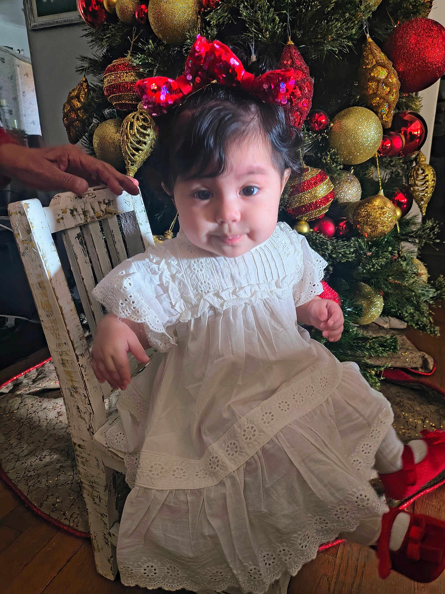 Gianna joined the competition — help win amazing prizes! toddler, child, white_dress, red_bow, red_shoes, chair, hand, christmas_tree, christmas_ornaments, holiday, decorations, indoors, wood_floor, festive, portrait, cute, smile, person, celebration, seasonal