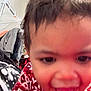 Rihannon joined the competition — help win amazing prizes! child, toddler, face, smile, clothing, sweater, red, white, indoor, hanger, clothes, person, happy, close_up, expression, young, cute, portrait, blur, background