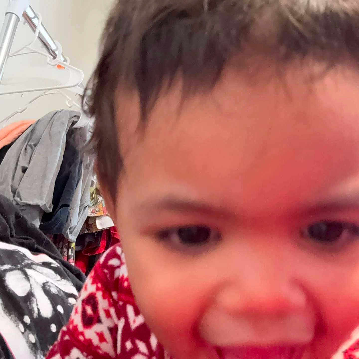 Rihannon joined the competition — help win amazing prizes! background, blur, child, close_up, clothes, clothing, cute, expression, face, hanger, happy, indoor, person, portrait, red, smile, sweater, toddler, white, young