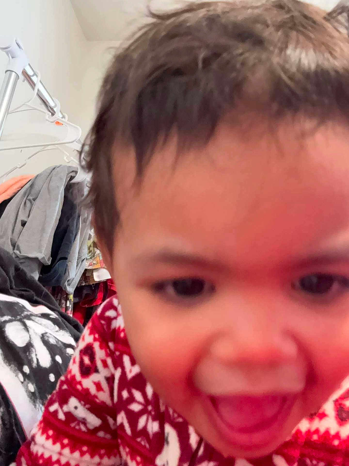 Rihannon joined the competition — help win amazing prizes! child, toddler, face, smile, clothing, sweater, red, white, indoor, hanger, clothes, person, happy, close_up, expression, young, cute, portrait, blur, background