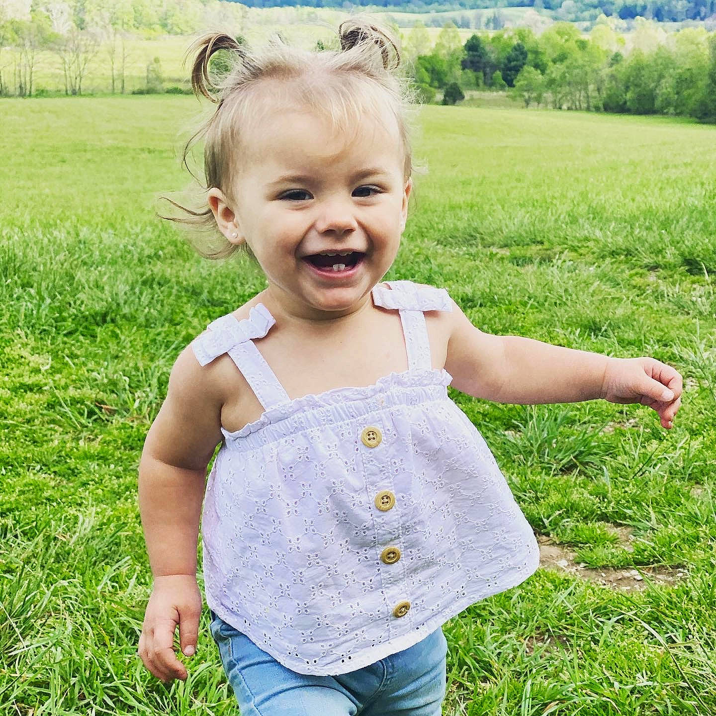 Emmie Lou is registered to the contest to win money with this photo: baby_toddler_clothing, clothing, eye, face, finger, grass, green, hair, happy, head, joy, leaf, mammal, people_in_nature, person, plant, skin, sleeve, smile, sunlight