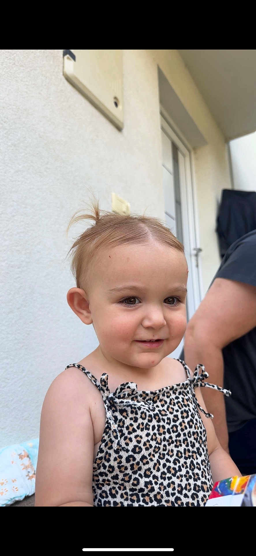 Keila joined the competition — help win amazing prizes! toddler, child, smiling, leopard_print, dress, outdoor, person, baby, hair, cute, face, skin, door, wall, adult, shoulder, standing, happy, young, casual
