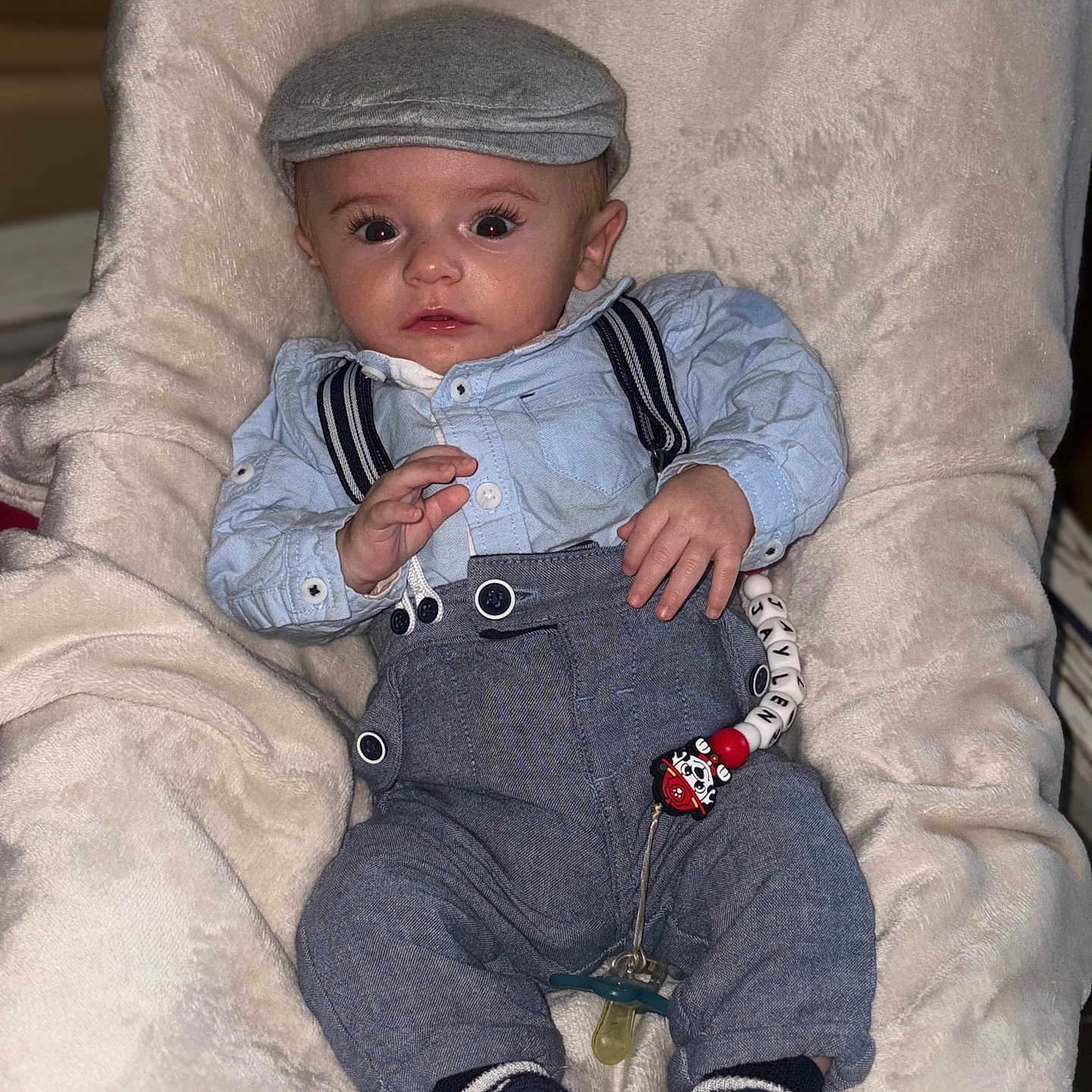 Jaylen participe au concours pour gagner de l'argent avec cette photo : accessory, baby, cap, child, clothing, cute, expression, face, fashion, hat, indoor, infant, pacifier, person, plush_chair, portrait, shoes, sitting, suspenders, young