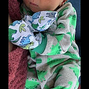 Robert is registered to the contest to win money with this photo: baby, baby_products, baby_toddler_clothing, cheek, child, collar, comfort, eye, green, happy, linens, neck, pattern, personal_protective_equipment, scarf, sitting, skin, sleeve, t_shirt, toddler