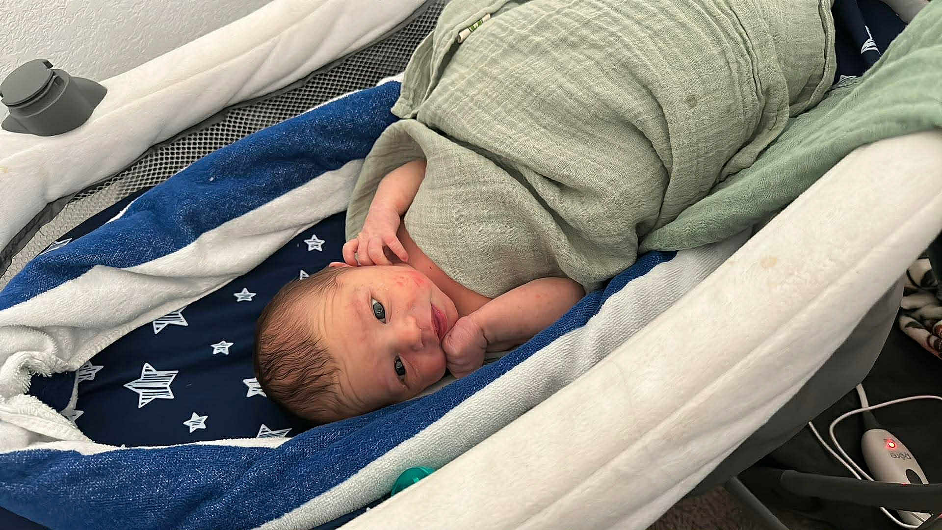 Rc Aka Reed Cameron is registered to the contest to win money with this photo: newborn, baby, infant, blanket, bassinet, bedding, blue, white, star_pattern, wrapped, sleeping, cozy, cute, small, hand, face, head, indoors, resting, child