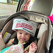 Lainey is registered to the contest to win money with this photo: baby, bodypart, car, car_interior, clothing, crib, cushion, face, finger, furniture, hand, hat, head, homedecor, infantbed, person, photography, portrait, transportation, vehicle