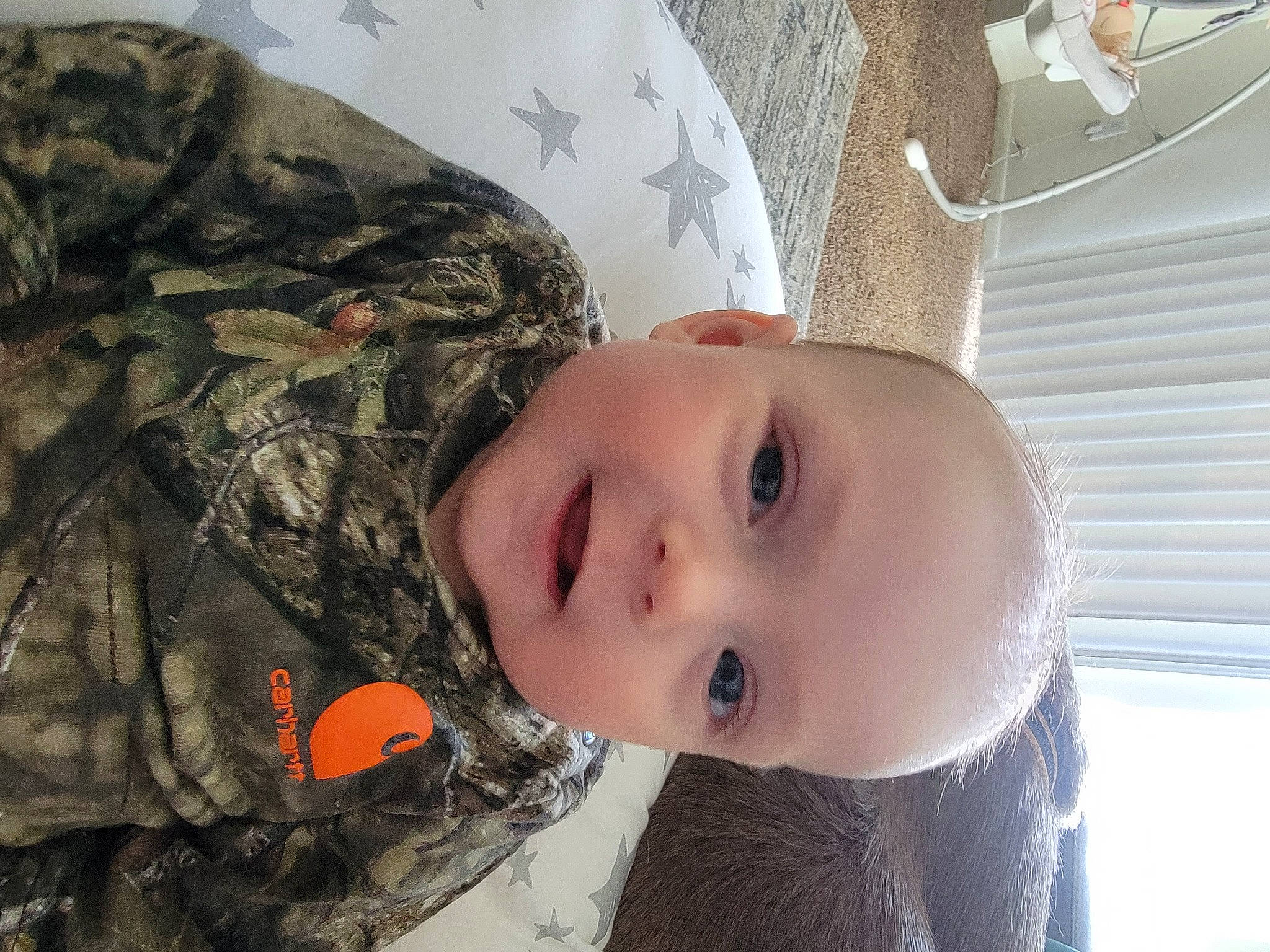 Haislee is registered to the contest to win money with this photo: army, baby, camouflage, child, eyelash, fur, military, military_camouflage, military_organization, military_person, military_uniform, pattern, person, plant, room, soldier, textile, toddler, tree, uniform