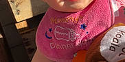 Willow is registered to the contest to win money with this photo: accessory, baby, child, closeup, clothing, colorful, cute, face, hand, happy, indoor, infant, person, pink_bib, playful, seat, smile, sunglasses, sunlight, toy