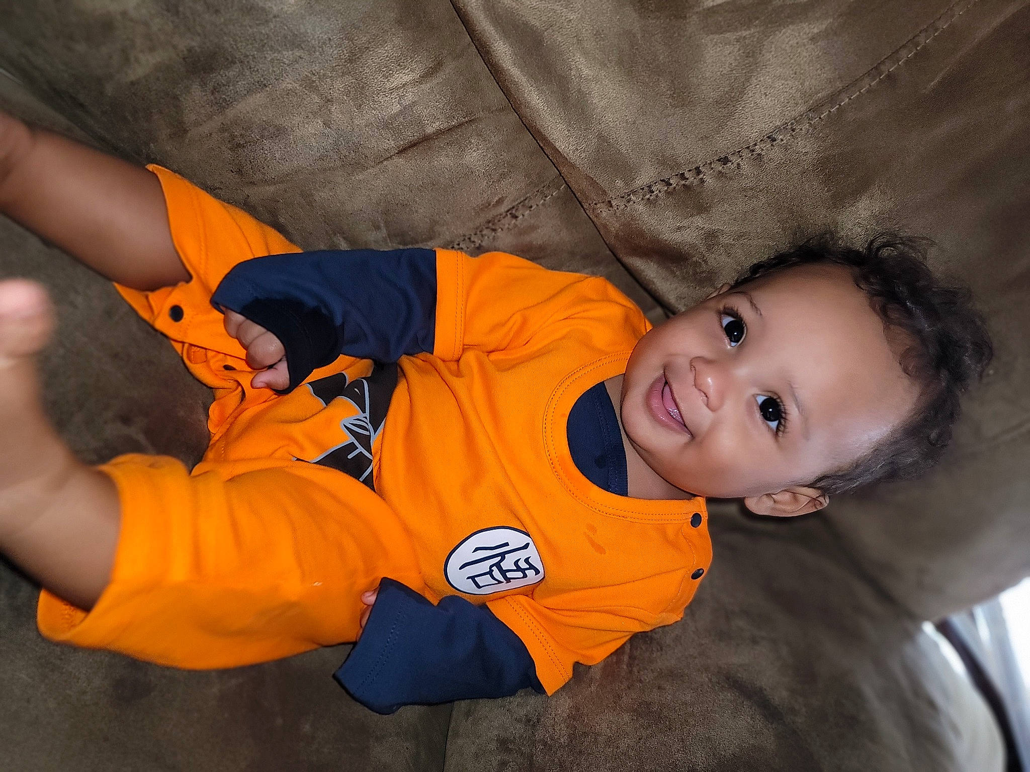 Davion is registered to the contest to win money with this photo: baby, baby_toddler_clothing, carmine, child, elbow, electric_blue, flash_photography, fun, gesture, hairstyle, happy, joy, orange, person, personal_protective_equipment, sitting, sleeve, smile, thumb, toddler