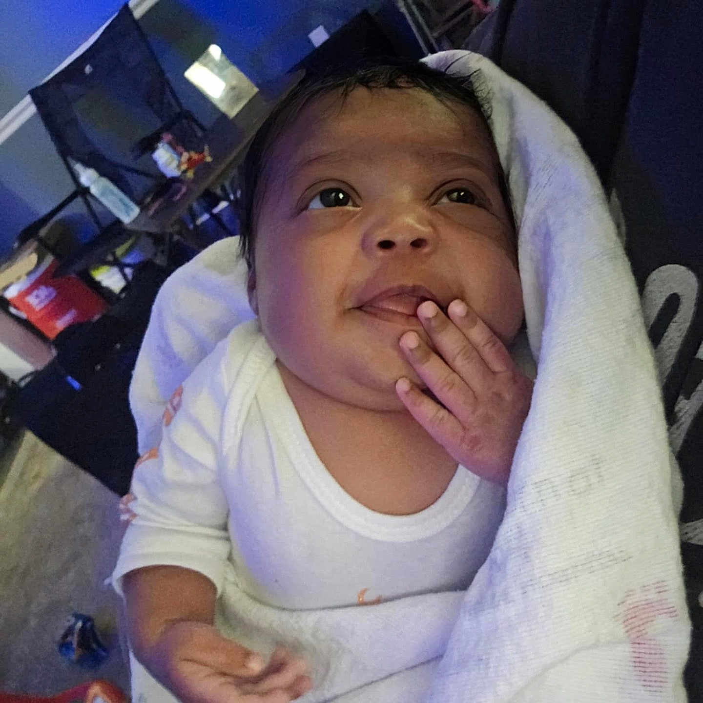 Journey is registered to the contest to win money with this photo: baby, blanket, cozy, curious, expression, face, hand, home, indoors, infant, person, portrait, sitting, skin, sleepwear, soft_light, toddler, white_clothing, wrapped, young_child