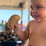 Chiara participe au concours pour gagner de l'argent avec cette photo : toddler, child, bread, food, smile, happy, face, hand, skin, cheek, blue_eyes, indoor, blurred_background, holding, snack, cute, person, portrait, baby, expression