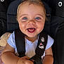 baby, child, car_seat, harness, blue_eyes, smiling, happy, plush_toy, white_shirt, infant, closeup, cute, hands, seatbelt, indoor, portrait, person, young_child, face, safety