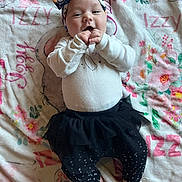 Isabella joined the competition — help win amazing prizes! baby, child, infant, blanket, headband, bow, tutu, leggings, stars, flower_pattern, hand, feet, smiling, cute, lying_down, fabric, pattern, colorful, playful, indoors