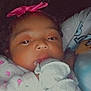 Evonna is registered to the contest to win money with this photo: baby, infant, child, pink_bow, mittens, floral_clothing, closeup, portrait, indoors, person, cute, young, headwear, sleepwear, soft_lighting, newborn, face, hand, cozy, calm