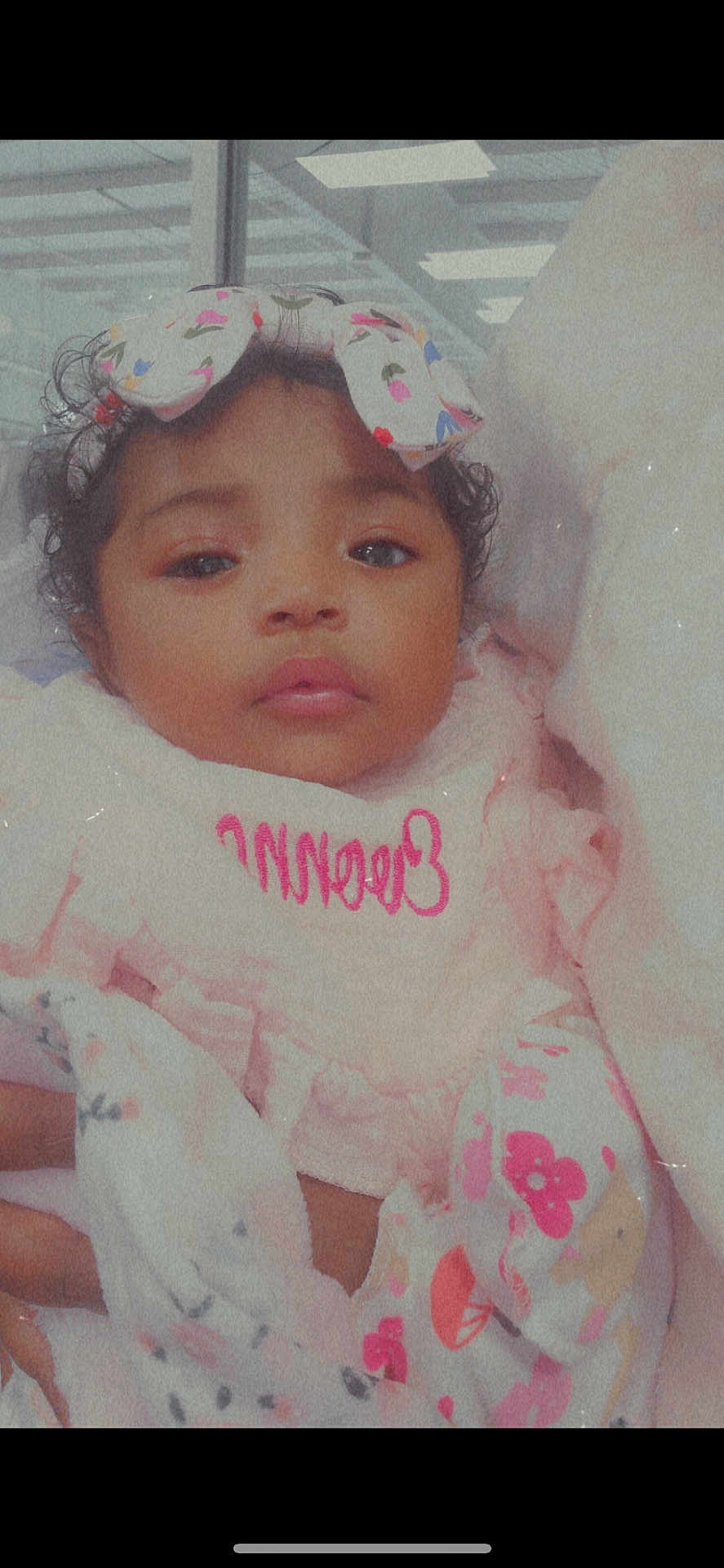 Evonna is registered to the contest to win money with this photo: baby, child, face, headband, bow, blanket, clothing, pattern, pink, flower, curly_hair, portrait, indoors, soft_lighting, cute, infant, person, gaze, wrapped, cozy