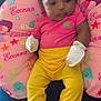 baby, child, pink_shirt, yellow_pants, yellow_socks, mittens, bows, curly_hair, pillow, ocean_theme, mermaid, starfish, jellyfish, whale, coral, indoor, cute, resting, infant, colorful
