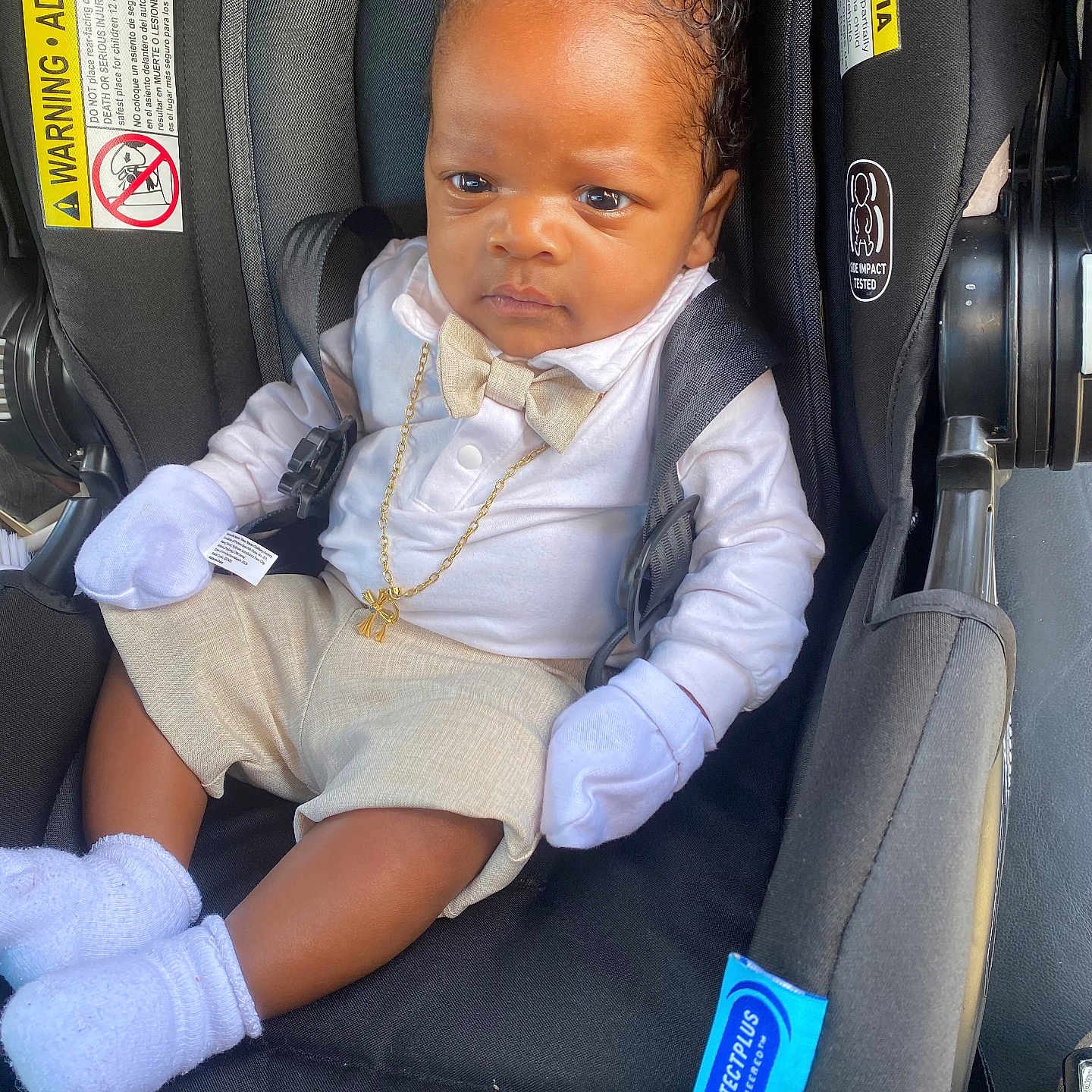 Righteous joined the competition — help win amazing prizes! baby, child, car_seat, infant, clothing, mittens, socks, bow_tie, shorts, white_shirt, black_car_seat, gold_chain, seat_belt, infant_accessory, protective_gear, snugride_lite, cute, portrait, indoors, serious_expression