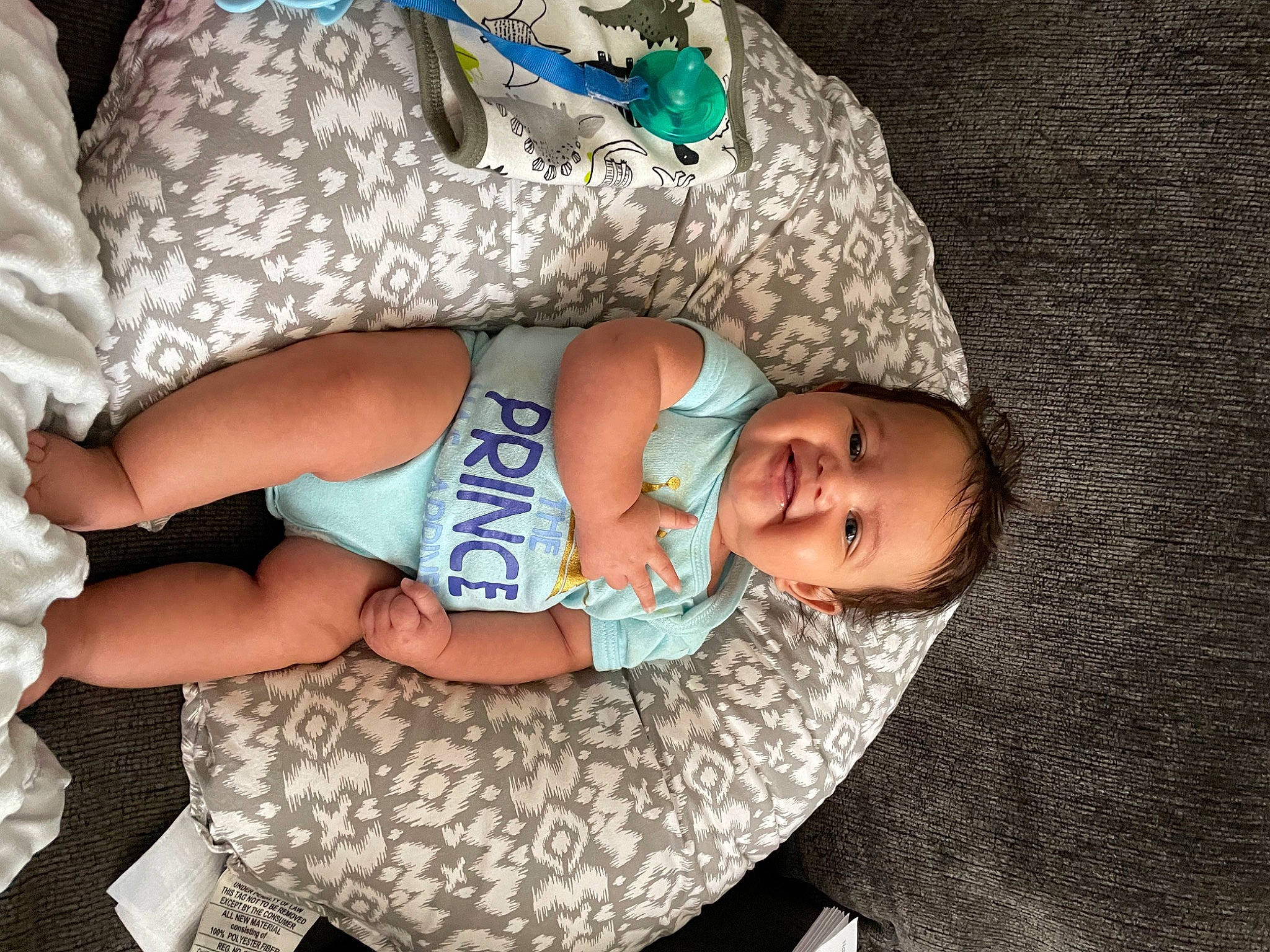 Brayson is registered to the contest to win money with this photo: baby, baby_products, baby_toddler_clothing, cheek, child, comfort, fashion_accessory, finger, grass, hat, headgear, human_leg, joy, nail, pattern, person, sitting, skin, sleeve, textile