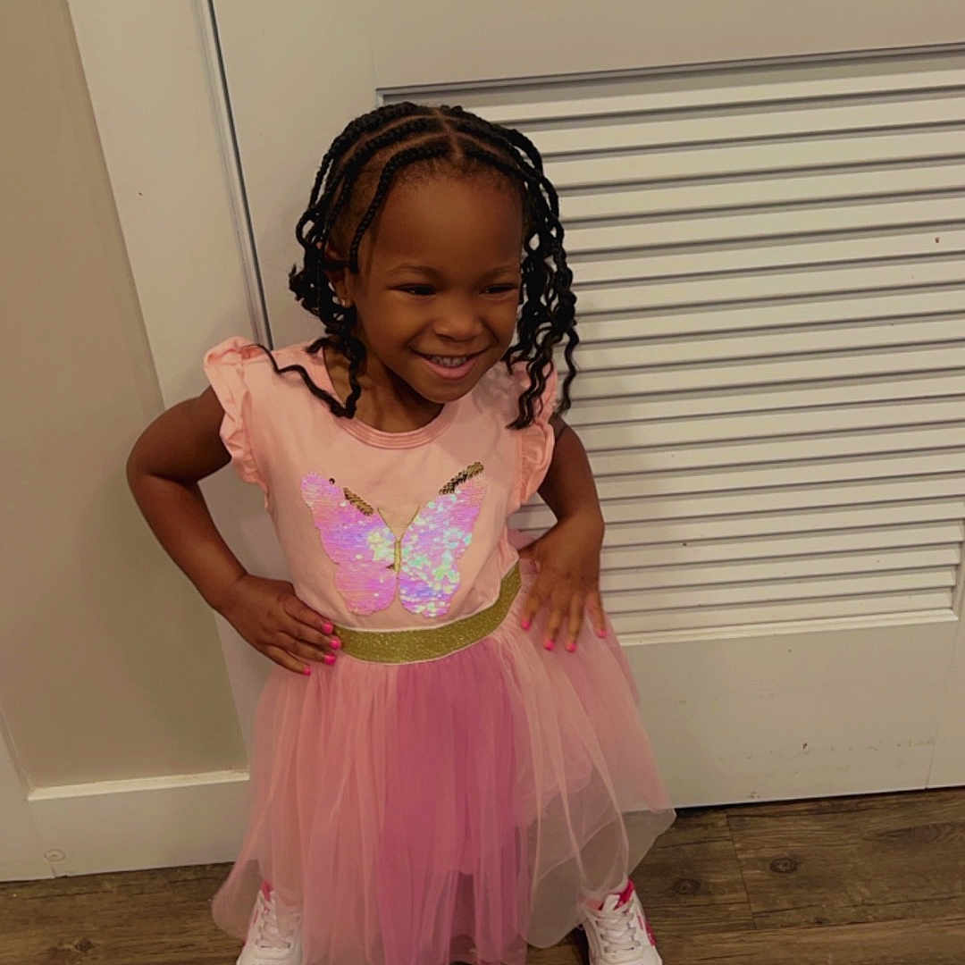 Zuri joined the competition — help win amazing prizes! accessories, child, clothing, door, dress, face, female, footwear, girl, hardwood, head, person, photography, portrait, purple, sandal, shoe, sitting, skirt, wood