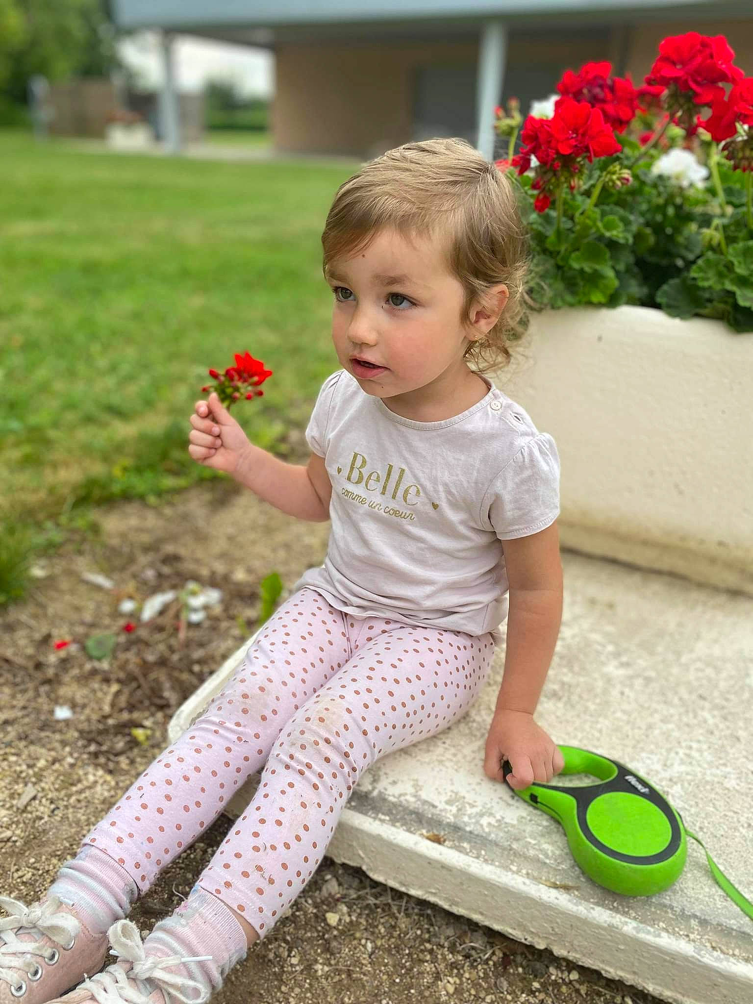 Elza participe au concours pour gagner de l'argent avec cette photo : baby_toddler_clothing, child, flower, flowerpot, fun, grass, green, happy, houseplant, leisure, magenta, people_in_nature, person, petal, photograph, pink, plant, shoe, sleeve, toddler