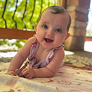 Ariella is registered to the contest to win money with this photo: baby, smiling, infant, outdoor, blanket, close_up, happy, face, child, person, cute, portrait, natural_light, skin, young, crawling, toy, playful, bright, daylight