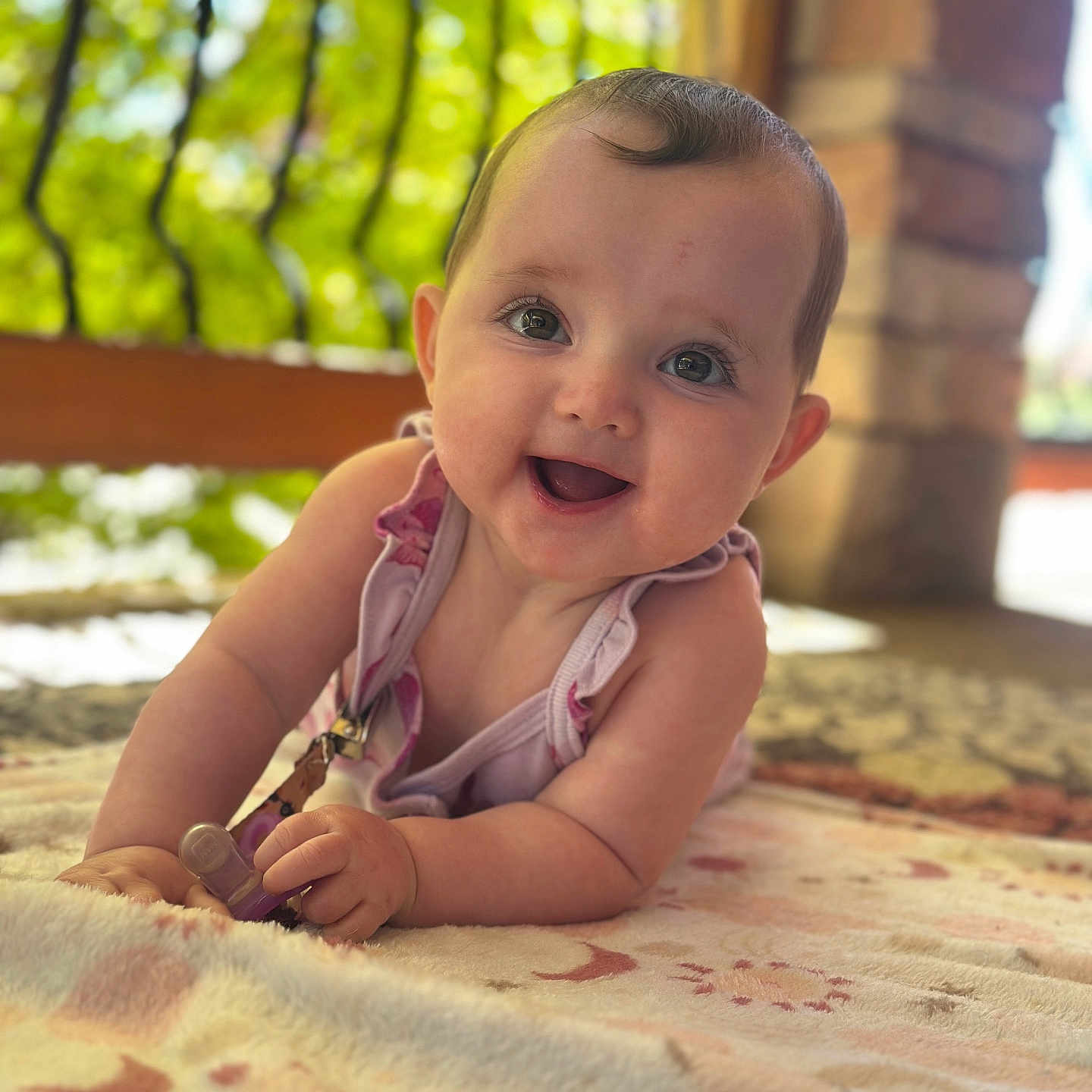 Ariella is registered to the contest to win money with this photo: baby, smiling, infant, outdoor, blanket, close_up, happy, face, child, person, cute, portrait, natural_light, skin, young, crawling, toy, playful, bright, daylight