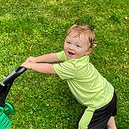 Brodhi joined the competition — help win amazing prizes! child, toddler, grass, green_shirt, black_shorts, toy, lawnmower, outdoor, playing, happy, smiling, grass_field, summer, fun, active, barefoot, sunlight, nature, cute, young