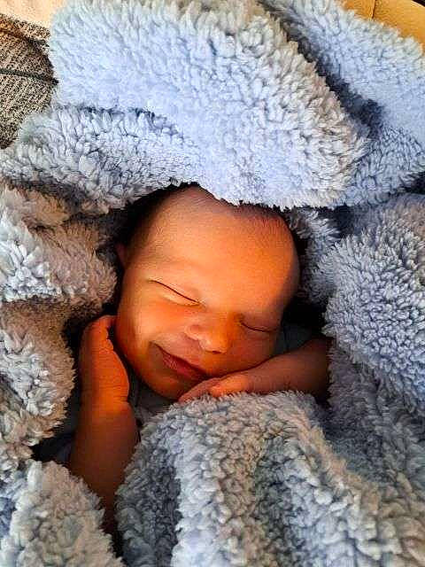 Zane is registered to the contest to win money with this photo: arm, baby, baby_sleeping, cap, cheek, child, comfort, eye, freezing, hand, head, headgear, human_body, knit_cap, linens, mouth, nose, person, skin, textile