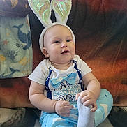 Wyatt is registered to the contest to win money with this photo: baby, child, bunny_ears, pajamas, bowtie, sock, couch, blanket, whale_pattern, indoor, smiling, happy, cute, infant, headband, portrait, seated, plush, cozy, playful