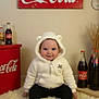 Amelia is registered to the contest to win money with this photo: baby, child, smiling, hoodie, white_clothing, red_shoes, sitting, rug, coca_cola, bottles, vintage, advertisement, indoor, cute, face, happy, fuzzy, toy, decor, portrait