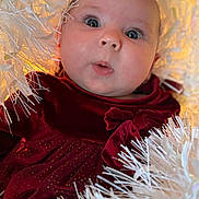 Amelia is registered to the contest to win money with this photo: baby, infant, face, eyes, clothing, dress, velvet, red, white, decoration, holiday, curious, cute, portrait, closeup, child, soft, fluffy, festive, expression