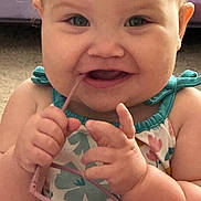 Lyla joined the competition — help win amazing prizes! baby, blue_eyes, cheeks, chewing, child, close_up, cute, expression, face, fingers, floral_dress, glasses, hands, indoor, infant, person, playful, skin, smile, young