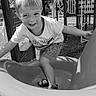 Kayden is registered to the contest to win money with this photo: child, playground, slide, smile, outdoor, sand, shorts, tshirt, happy, summer, play, fun, person, sandals, climbing, park, daylight, monochrome, young, activity