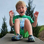 Kayden is registered to the contest to win money with this photo: child, boy, green_shirt, shorts, outdoor, happy, laughing, sitting, concrete, shoes, trees, nature, casual, daylight, playful, portrait, smile, grass, fun, youth