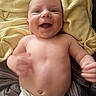 Colten is registered to the contest to win money with this photo: baby, smiling, diaper, blanket, happy, infant, cute, face, skin, hands, lying, child, young, motion_blur, indoors, soft_light, yellow, comfort, candid, portrait