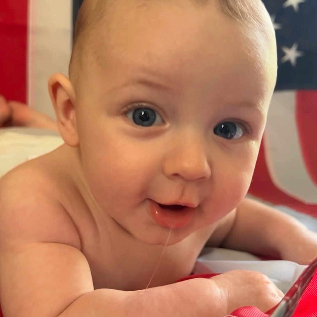 Aslan joined the competition — help win amazing prizes! baby, infant, face, drool, skin, arm, eyes, flag, american_flag, red, white, blue, portrait, cute, child, young, expression, background, closeup, person