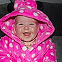 Arabella is registered to the contest to win money with this photo: baby, child, smiling, hooded_robe, pink, polka_dot, plush, happy, face, portrait, indoor, seated, cozy, couch, clothing, cute, infant, young, apparel, warm