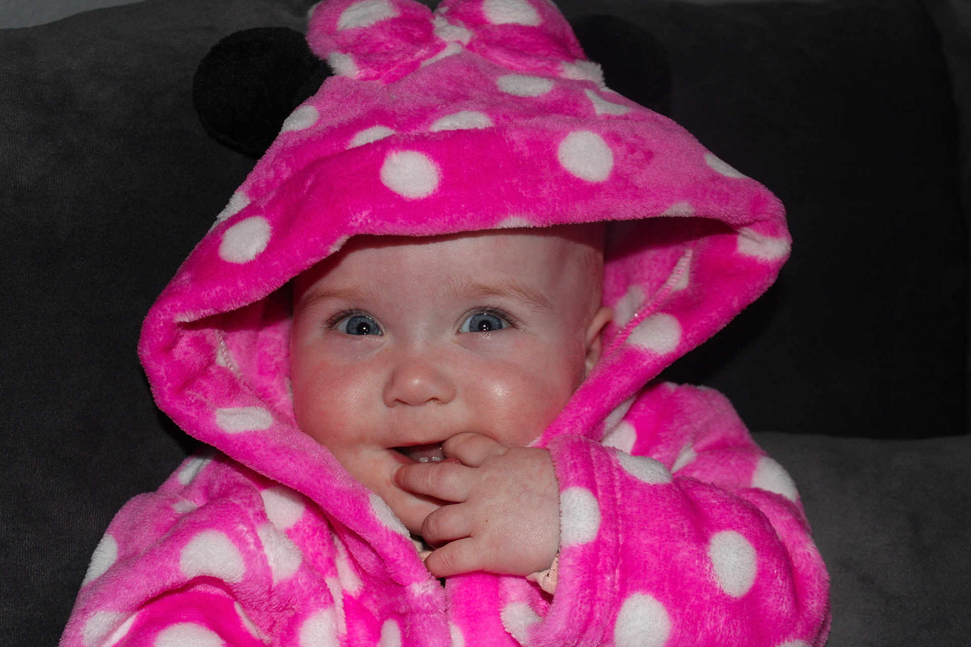 Arabella joined the competition — help win amazing prizes! baby, child, hoodie, pink, polka_dot, cute, face, hand, fingers, blue_eyes, soft, warm_clothing, indoor, portrait, infant, smiling, cozy, couch, expression, hood