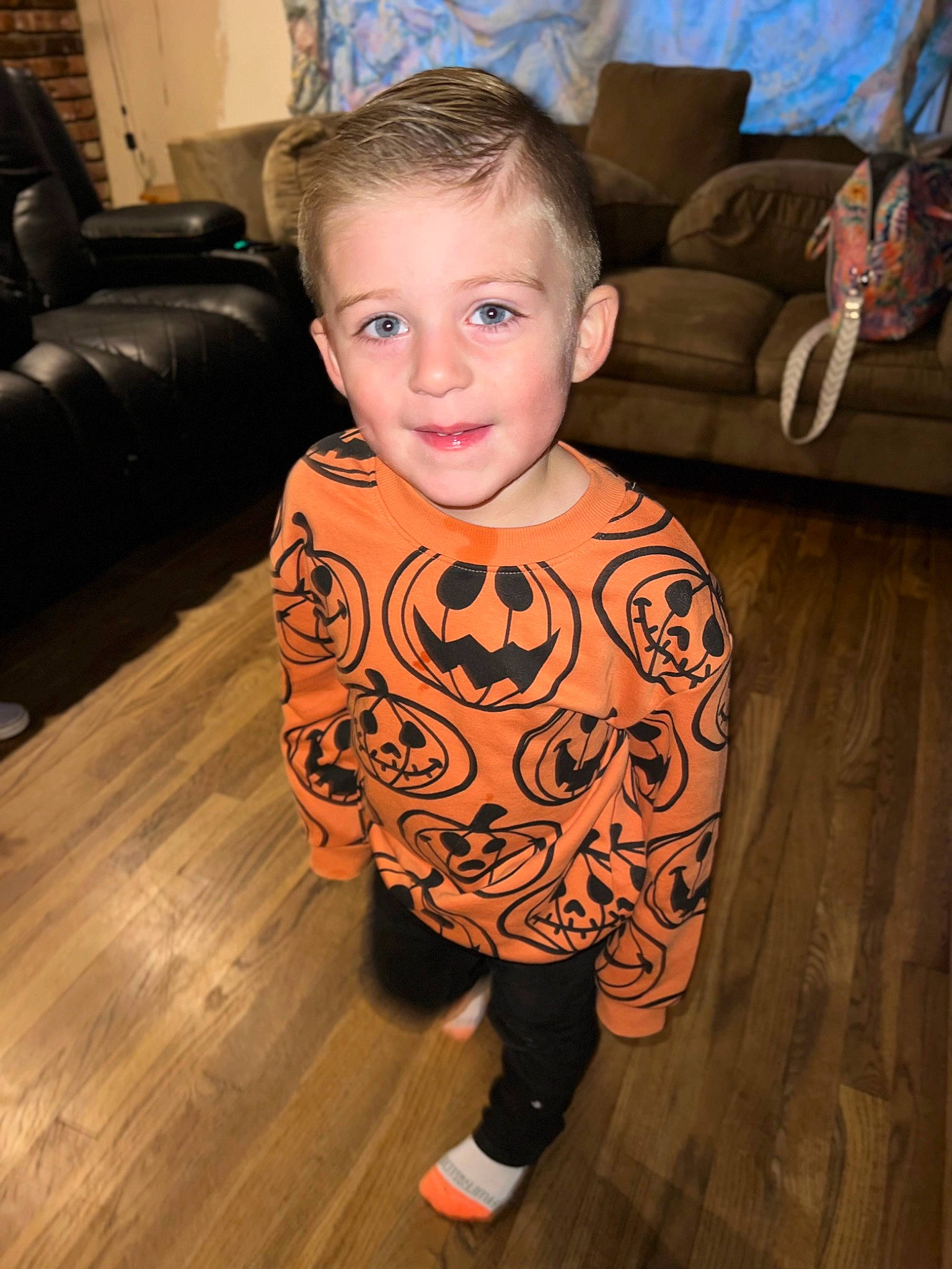 Kenny is registered to the contest to win money with this photo: baby_toddler_clothing, chair, child, comfort, couch, event, eye, floor, flooring, fun, happy, hardwood, head, iris, joy, living_room, person, sitting, sleeve, smile