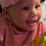 Nova Spencer is registered to the contest to win money with this photo: baby, child, infant, portrait, smiling, happy, pink_clothing, hair_bow, headband, toy, rattle, orange_toy, colorful, sitting, indoor, close_up, face, hands, cozy, playful