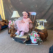 Jewells is registered to the contest to win money with this photo: toddler, child, pink_dress, headband, wooden_chair, books, teddy_bear, lamp, rotary_phone, basket, flowers, carpet, vintage, smile, indoor, portrait, decor, cute, happy, girl